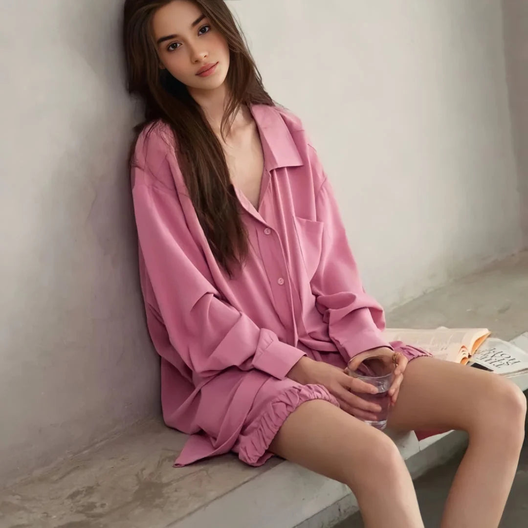 A model leaning against a wall, looking at the camera in the oversized pink cotton pajama set. - RoomDen