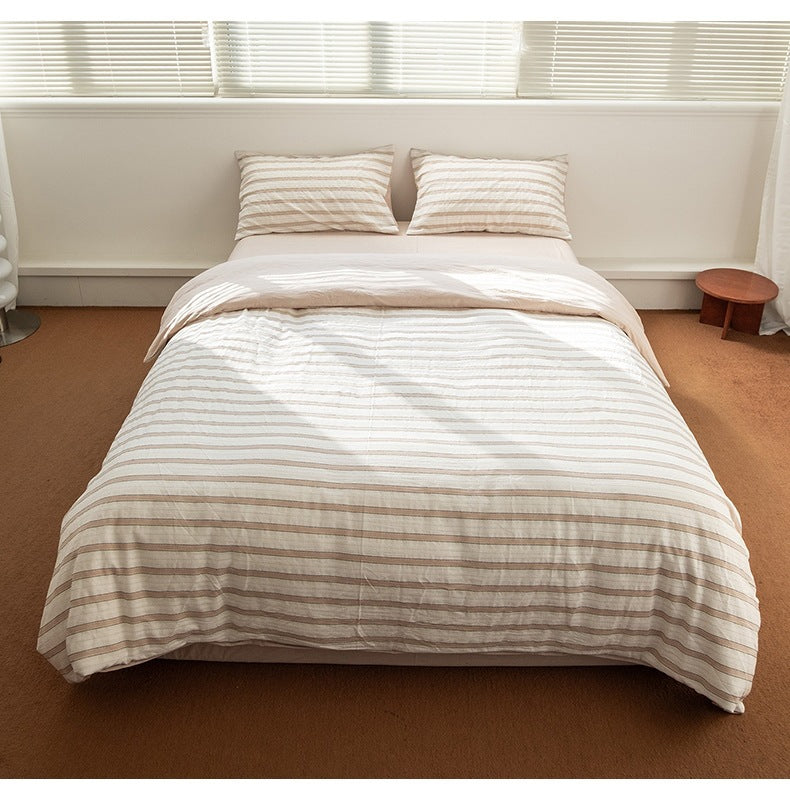 Striped cotton bedding viewed from the foot of the bed - Roomden