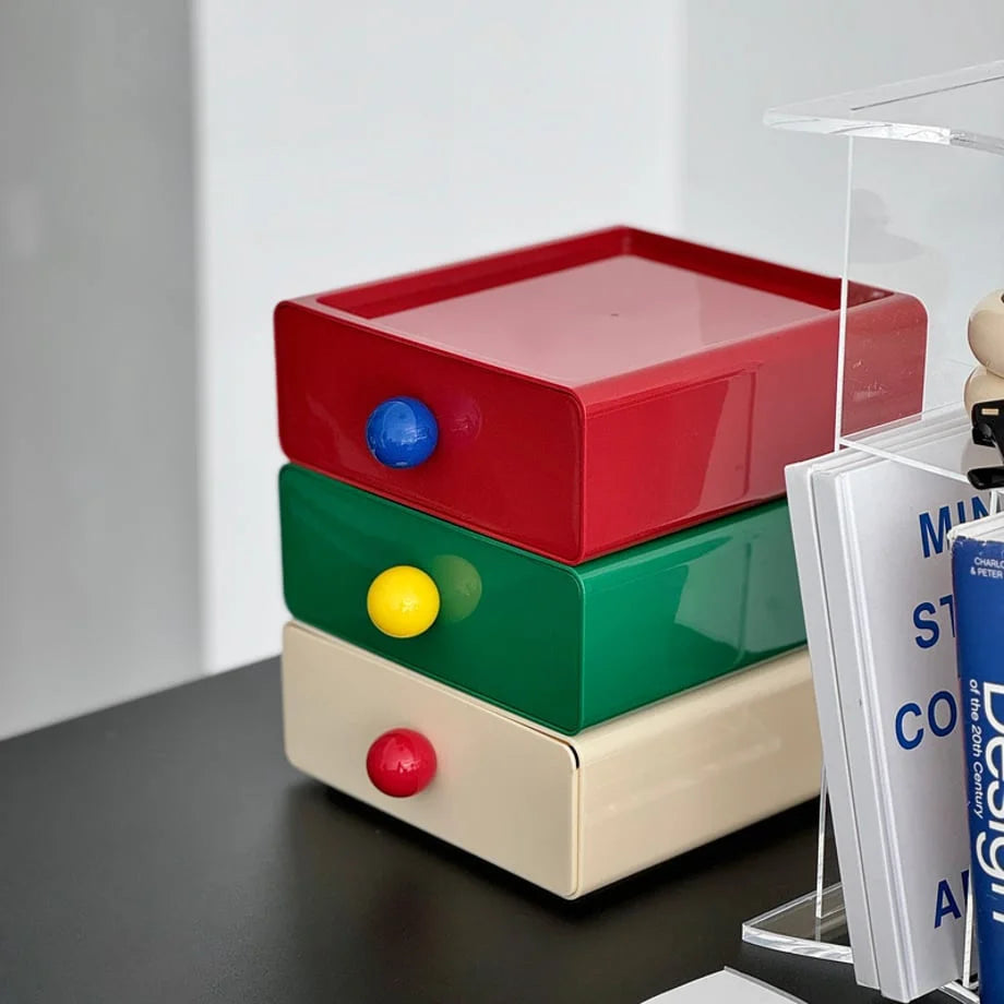 A close-up angle of the glossy red, green, and beige stackable desk drawers. - RoomDen