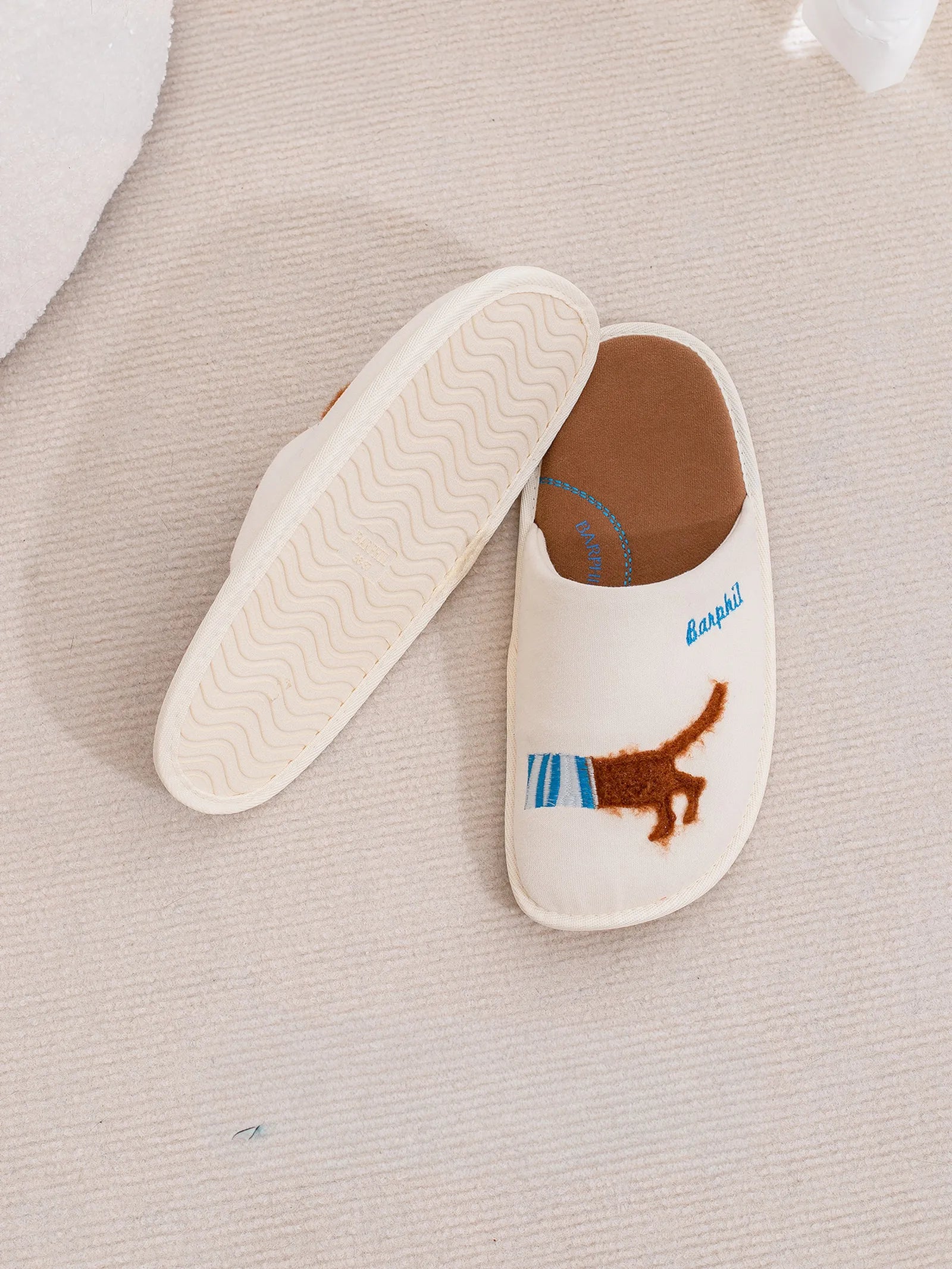 Bottom sole view of white slippers showing non-slip wave texture and soft construction