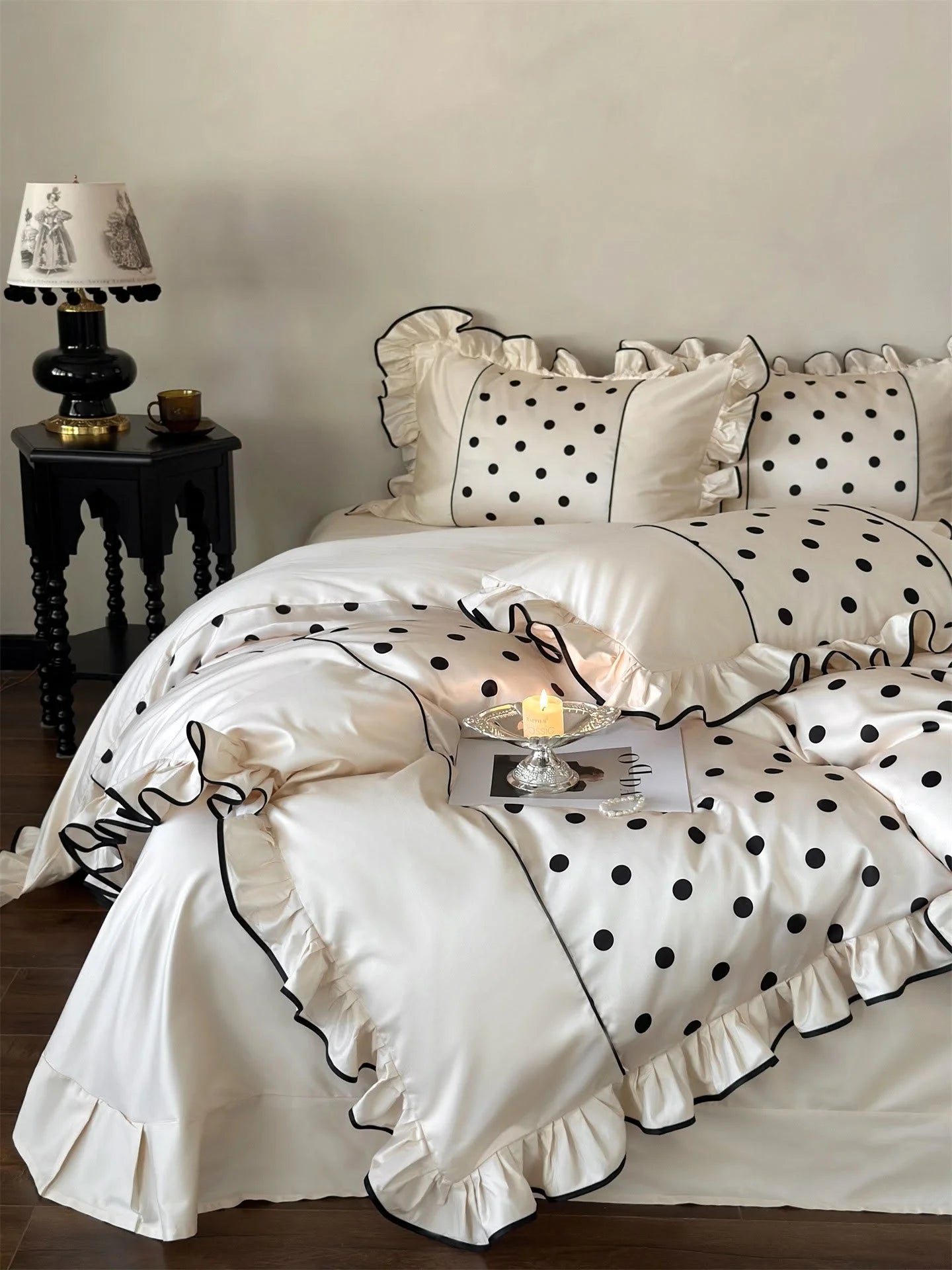 Angled view of the Creamy White & Black Polka Dot Ruffled Bedding Set, showing its silky sheen - RoomDen.