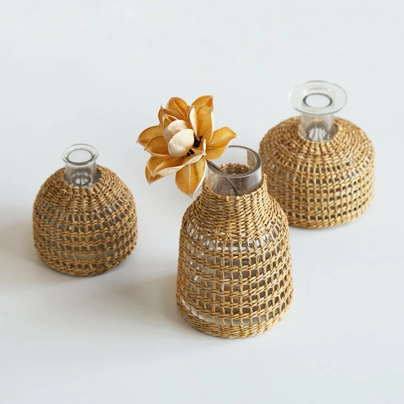 The three sizes of the Handwoven Rattan & Glass Bud Vase styled together on a clean white background.
