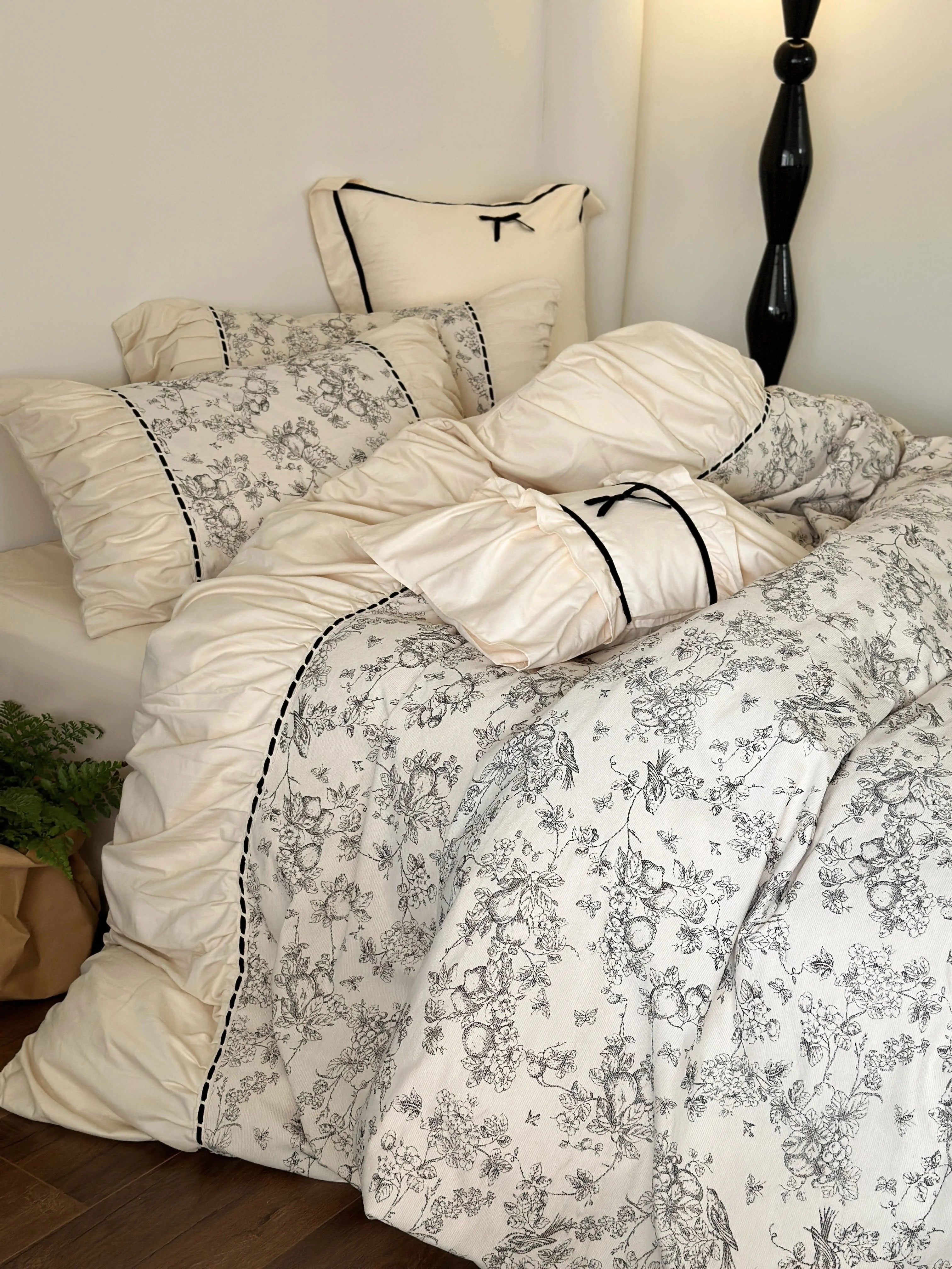 Close-up of the Ruffled Botanical Toile Washed Cotton Bedding Set in Cream Toile, showing the ruched details and bow accent. - RoomDen