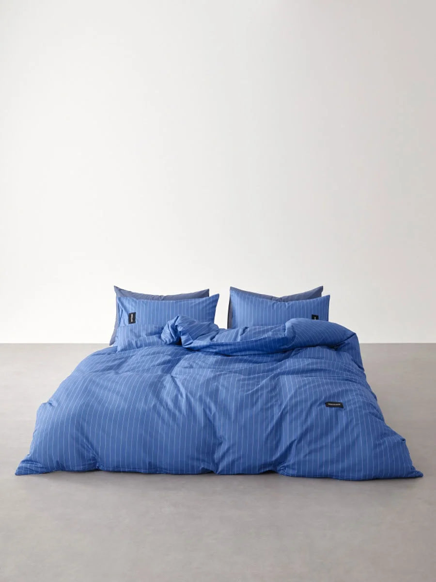 Full shot of the Denim Blue Pinstripe Washed Cotton Bedding Set on a minimalist floor setup - RoomDen.