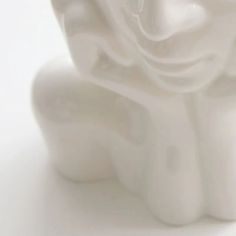 Close-up detail of the smooth, glossy finish on the white resin face vase - RoomDen.