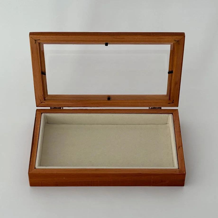 An open, empty wood jewelry box showing the soft beige velvet lining. - RoomDen