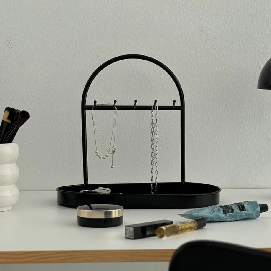 Angled view of the Black Metal Jewelry Organizer displaying silver and pearl necklaces. - RoomDen