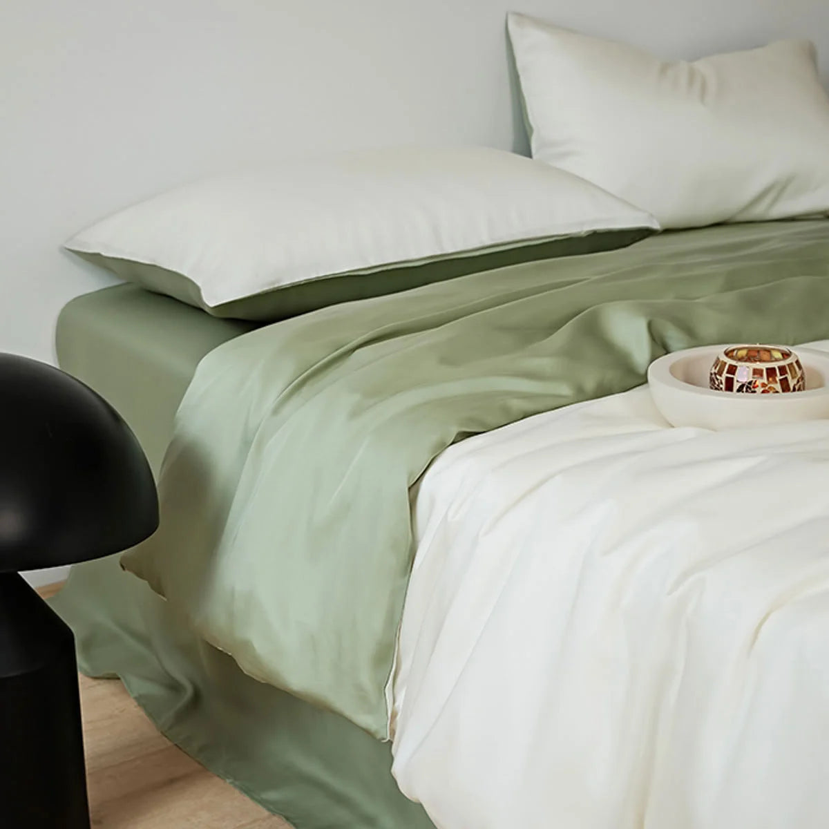 Angled view of the White & Sage Green bedding showing the contrast between the white duvet and green sheet.