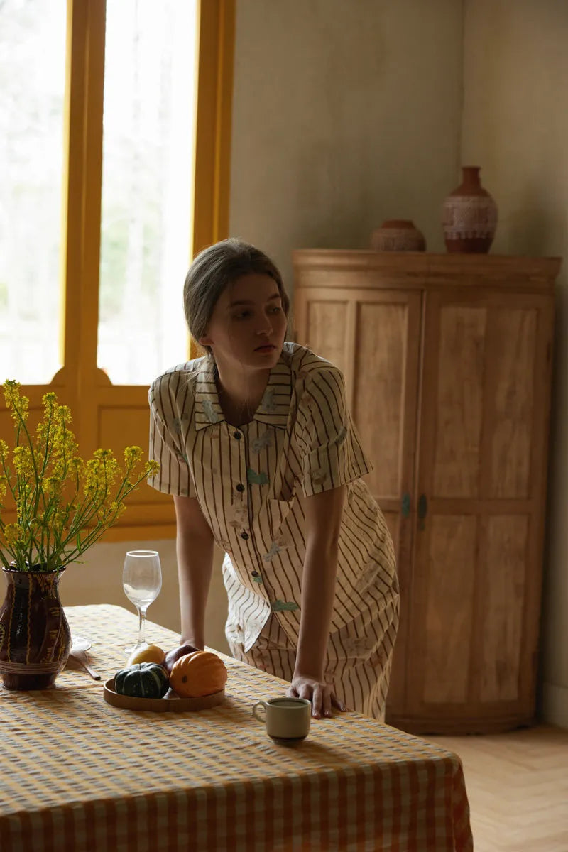 Lifestyle Shot of Woman Leaning on Table Wearing Striped Gauze Pajamas - RoomDen