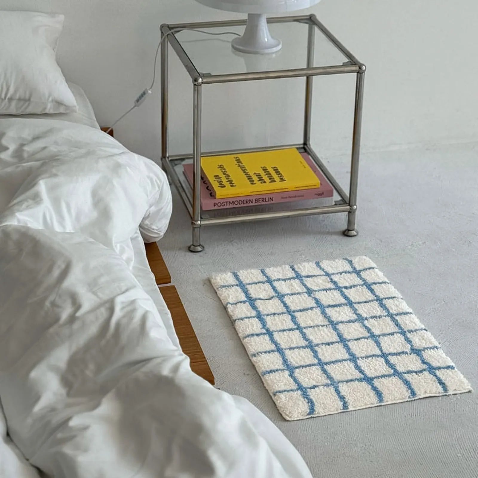 High Angle View of Blue Grid Accent Rug in Minimalist Bedroom Setting - RoomDen