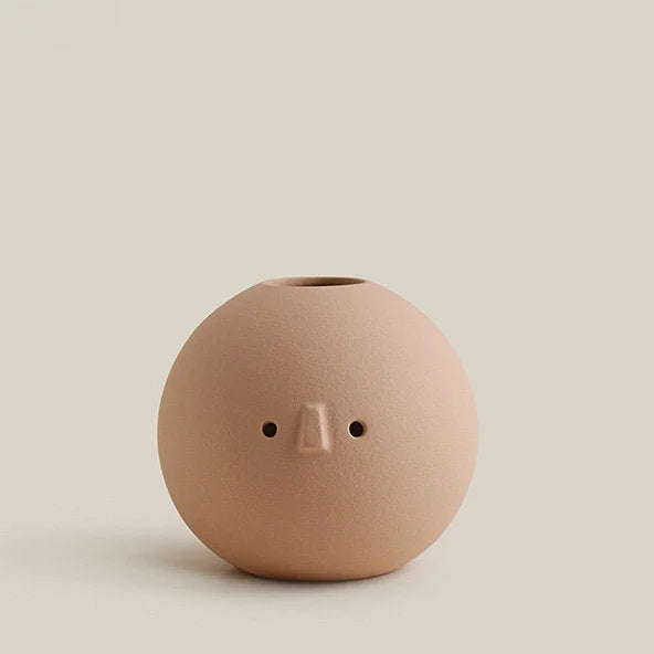 A studio shot of the beige Ball Frosted Minimalist Face Vase against a light beige background. - RoomDen