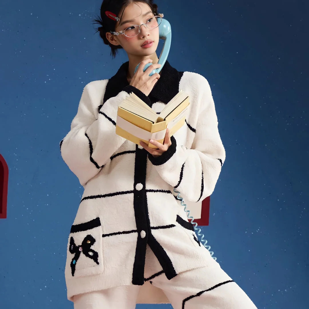 Model in the preppy striped fleece pajamas holding a book and a vintage-style telephone, looking thoughtful - RoomDen.