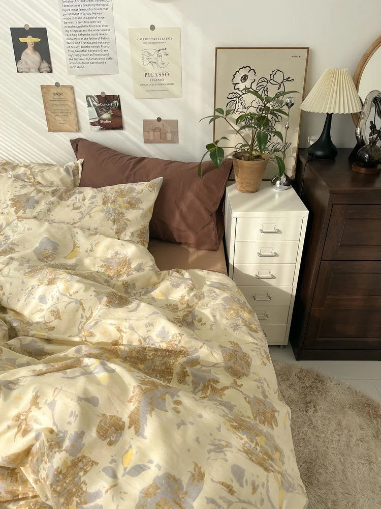 Angled view of the vintage floral cotton duvet cover, showing its soft texture next to a white nightstand and a potted plant. - RoomDen