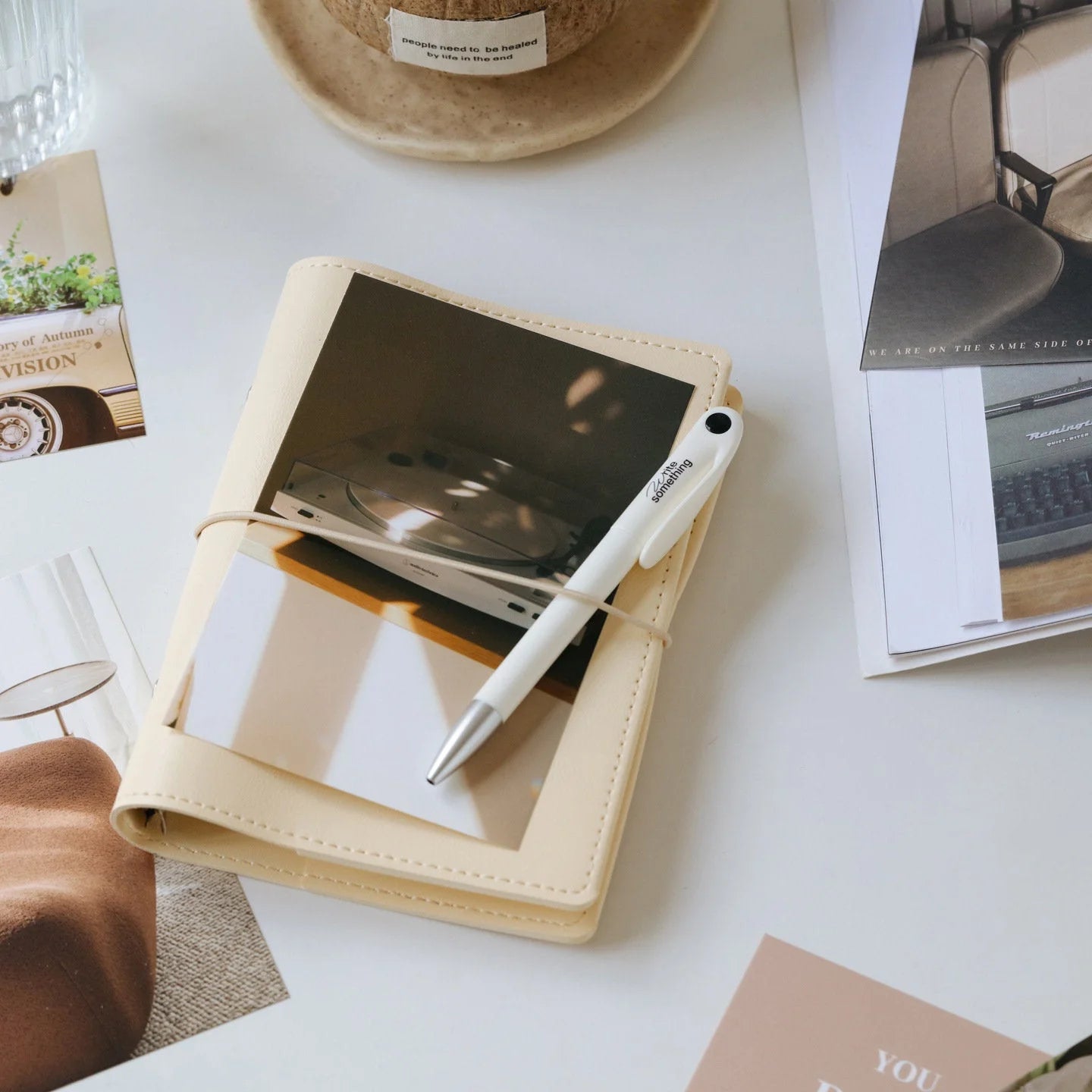 An aesthetic photo from the collage kit tucked into a beige journal, showing its versatility. - RoomDen