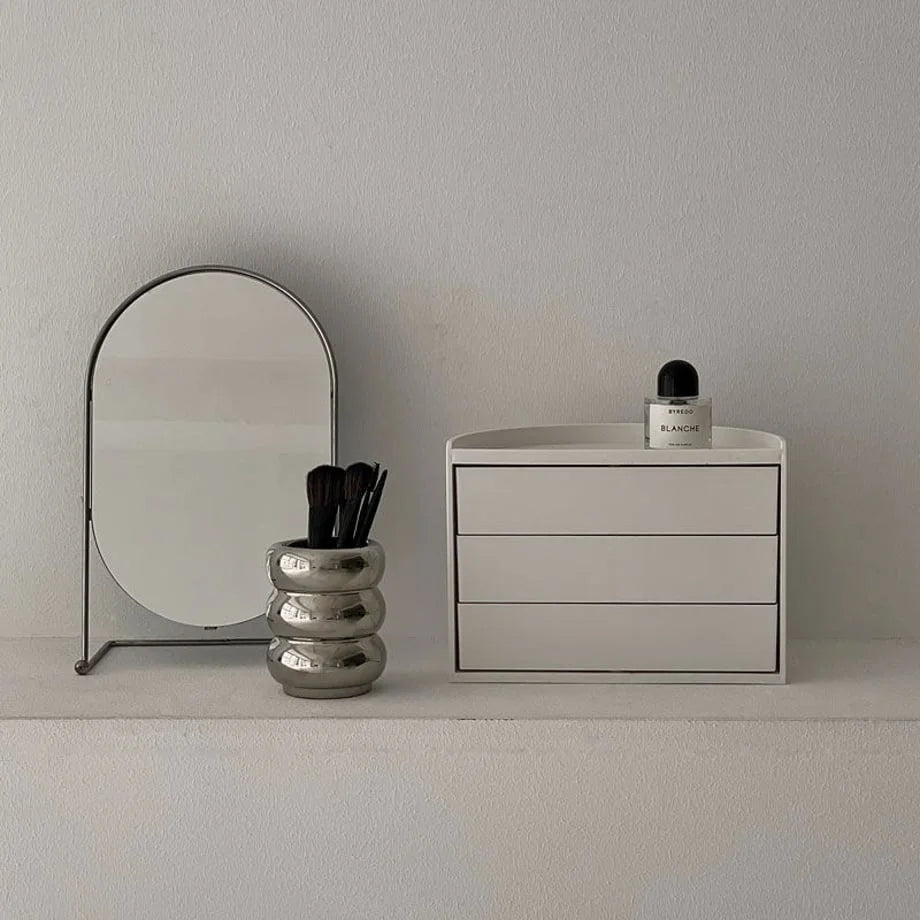 Front view of the closed Ribbed Swivel ABS Makeup Organizer on a white vanity shelf. - RoomDen