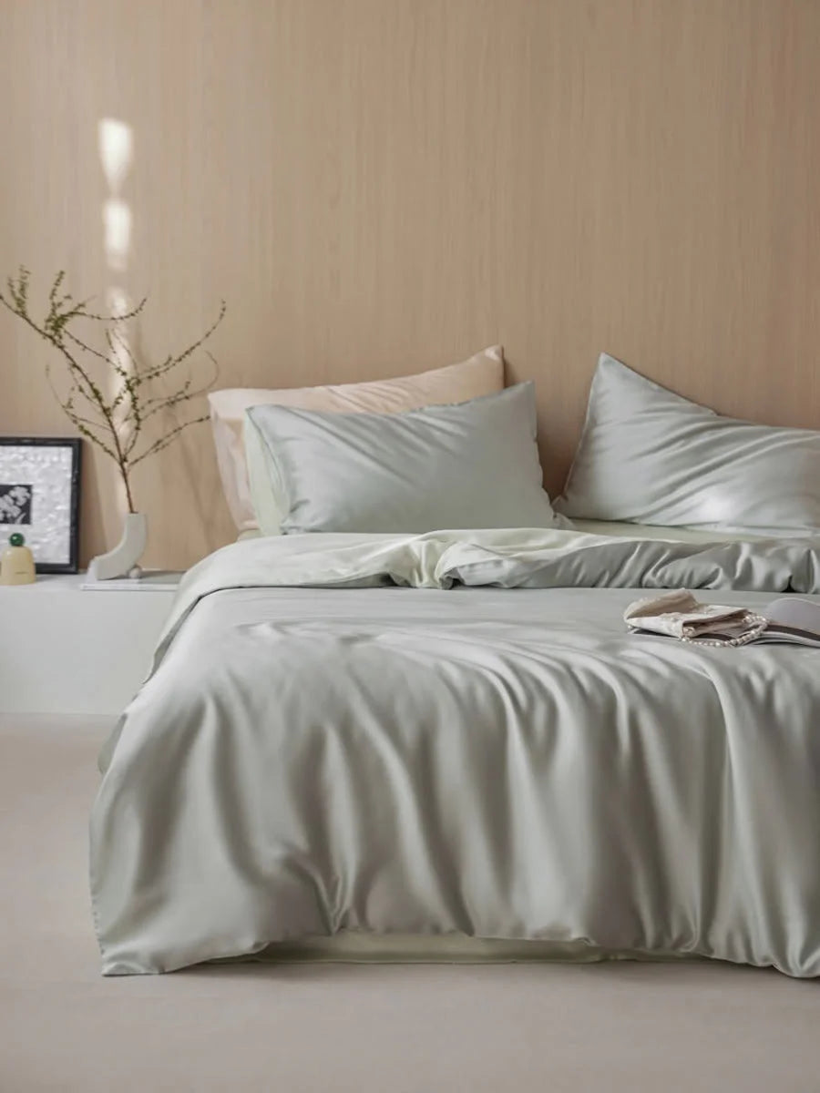 A bed dressed in the Sage Mist Cooling Tencel Bedding Set in a Japandi-style room with light wood walls. - RoomDen