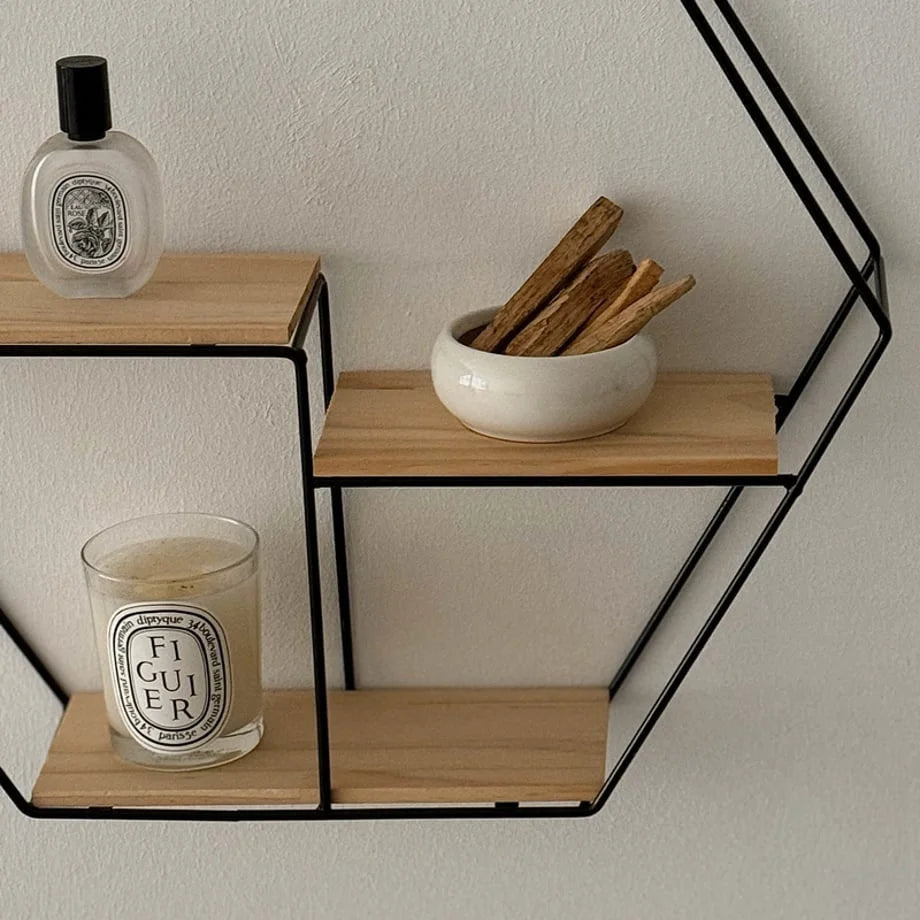 Close-up of the black metal frame and light wood shelves holding decorative items - RoomDen