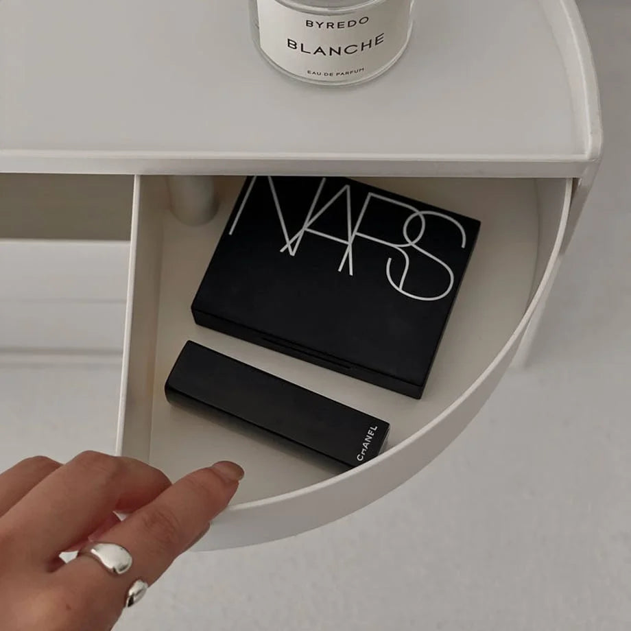 Hand opening a drawer of the makeup organizer, revealing NARS and Chanel cosmetics. - RoomDen