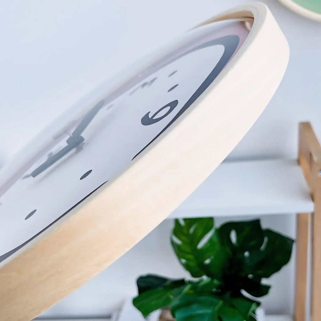 Close-up detail of the light wood-finish frame of the Doodle Wall Clock.