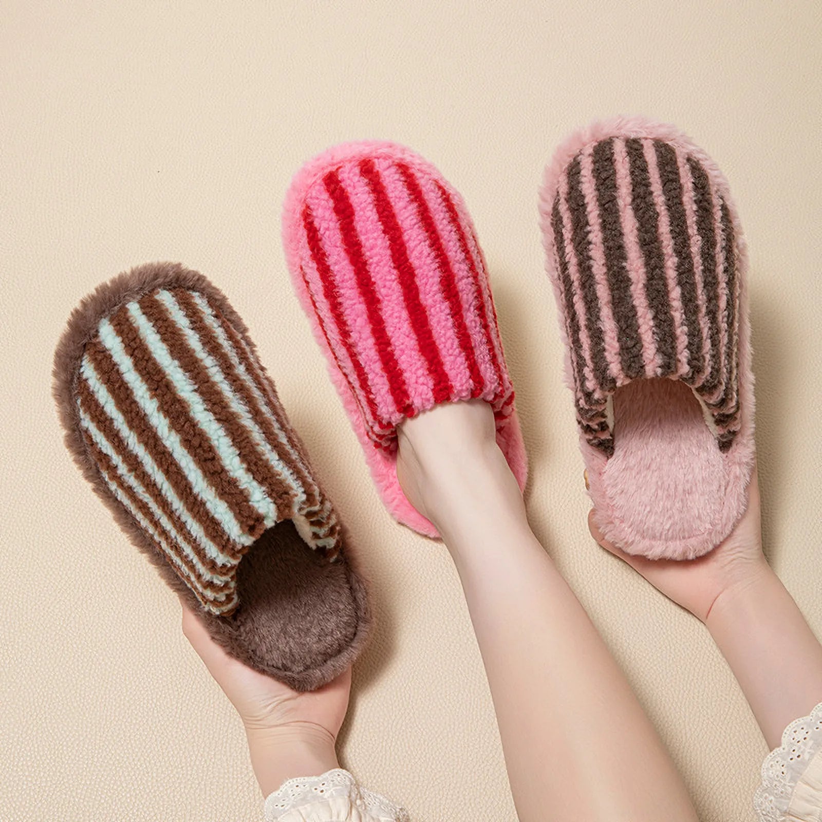 Hand holding three different colorways of fuzzy striped slides showing texture - RoomDen