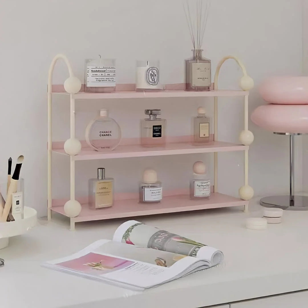 Front view of the Pastel Pink & Cream metal desk shelf on a tidy workspace with a magazine - RoomDen.