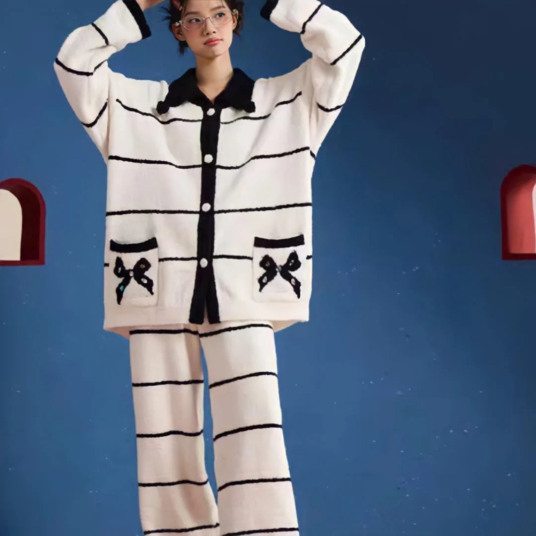 Full body shot of the model in the white and black striped fleece pajama set against a blue background - RoomDen.