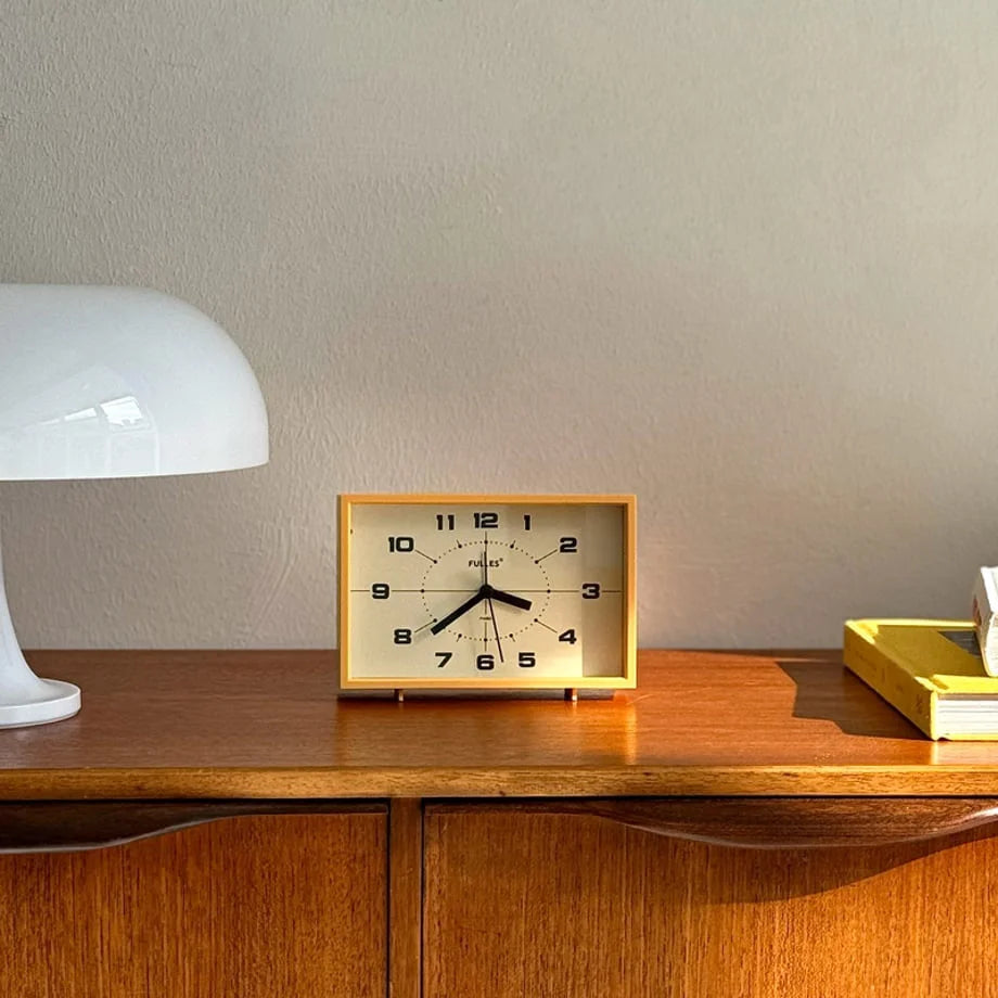 Mustard Yellow Retro Analog Table Clock on a wooden console table next to a white lamp - RoomDen.