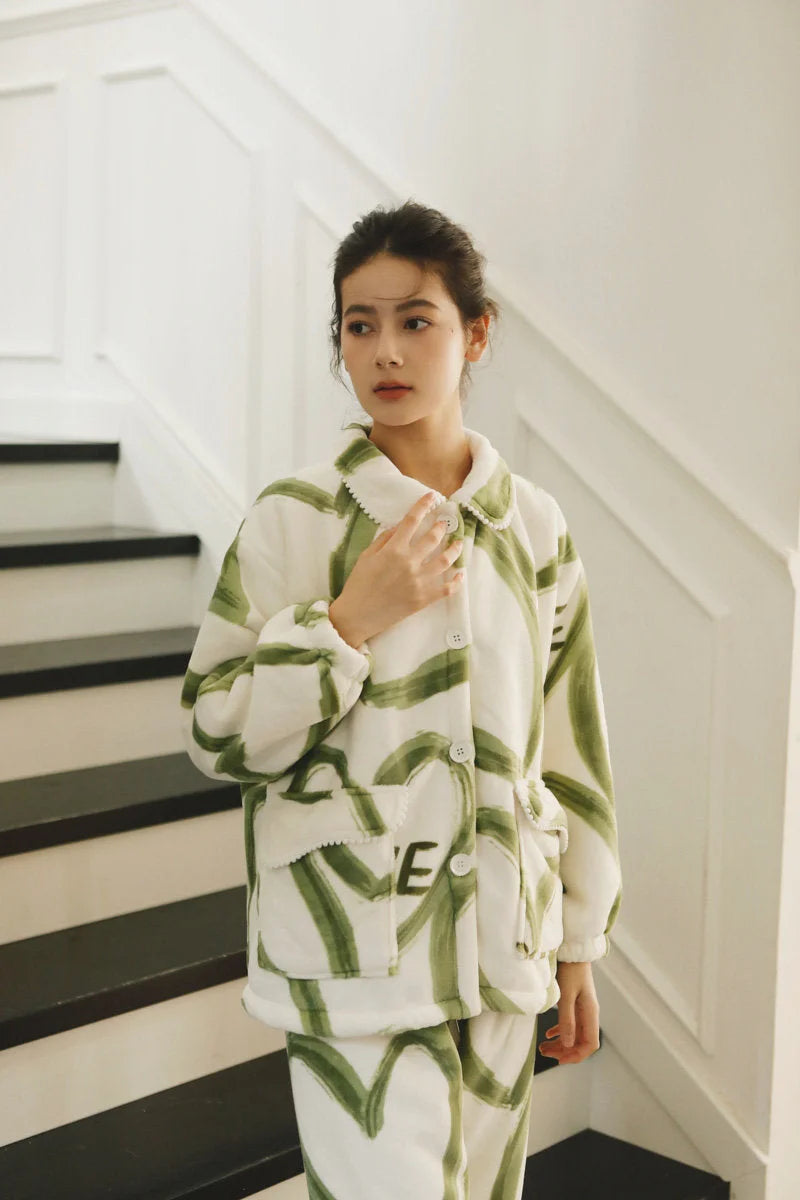 Model adjusting the scalloped Peter Pan collar of the green and white graffiti print fleece pajama top - RoomDen.