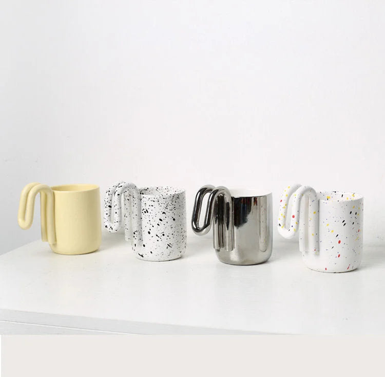 Full collection of loop handle mugs in yellow, black splatter, chrome silver, and confetti splatter - RoomDen