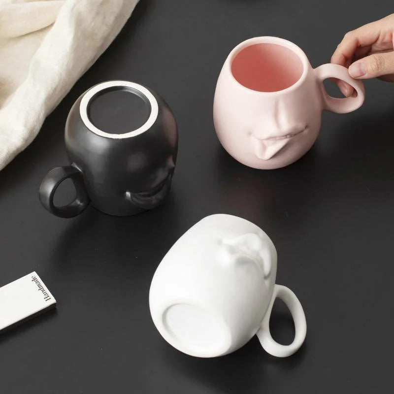 Top-down view showing the interior and base of the three abstract face ceramic mugs.
