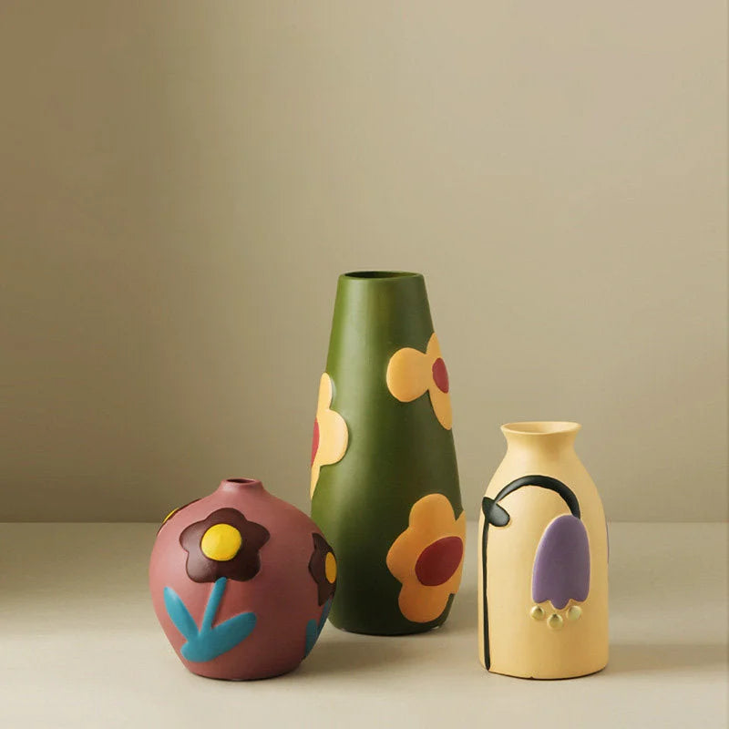 Three Pop Art Floral Ceramic Vases in mauve, green, and beige grouped together on a neutral surface. - RoomDen