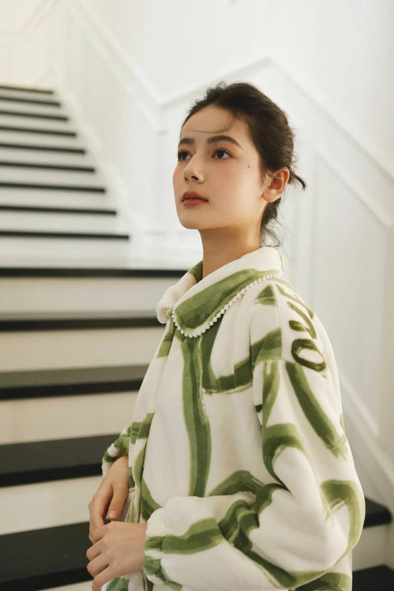 Upward-looking view of a model in the plush graffiti pajama set against a white staircase - RoomDen.