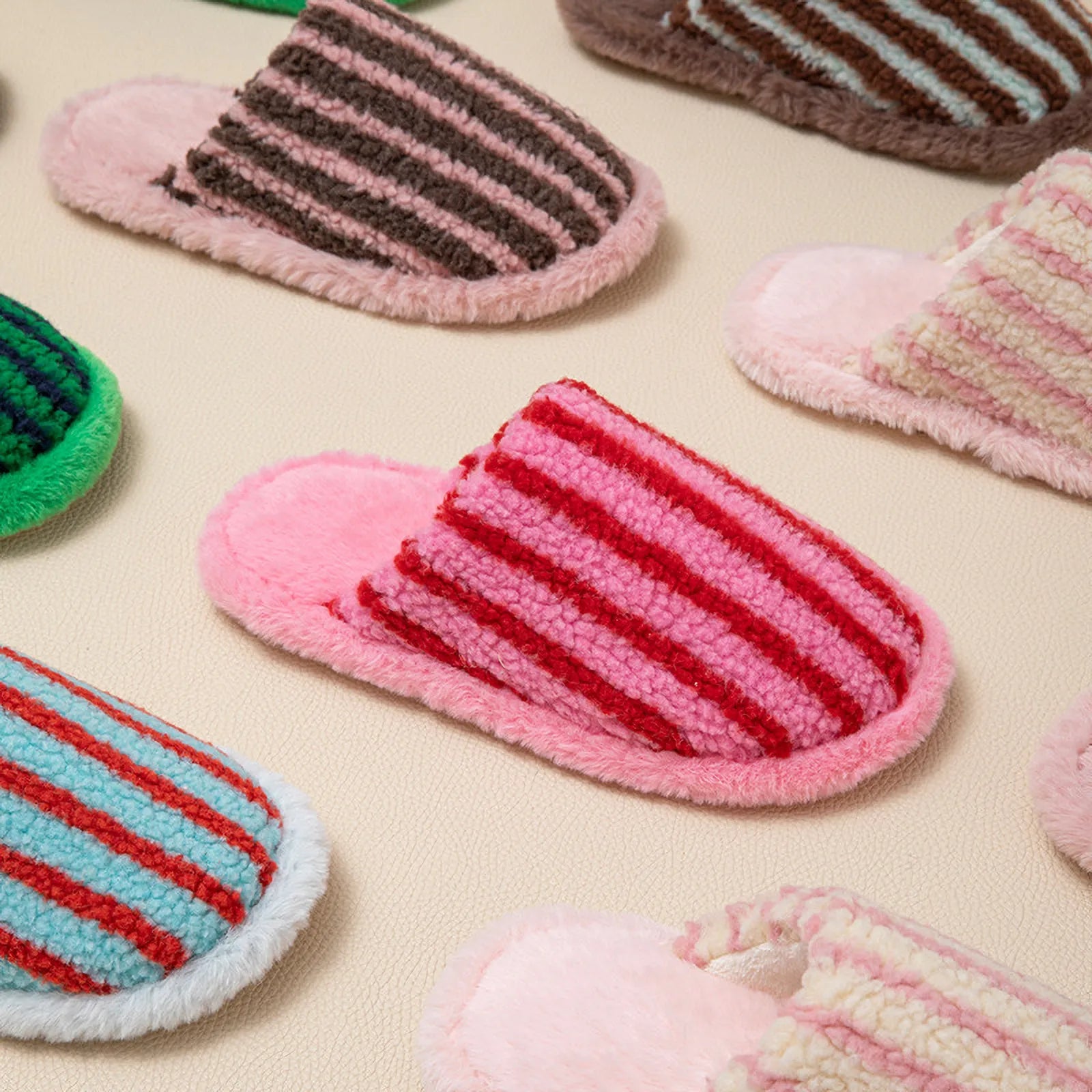 Group collection of Fuzzy Striped Plush House Slippers in various colors on beige background - RoomDen