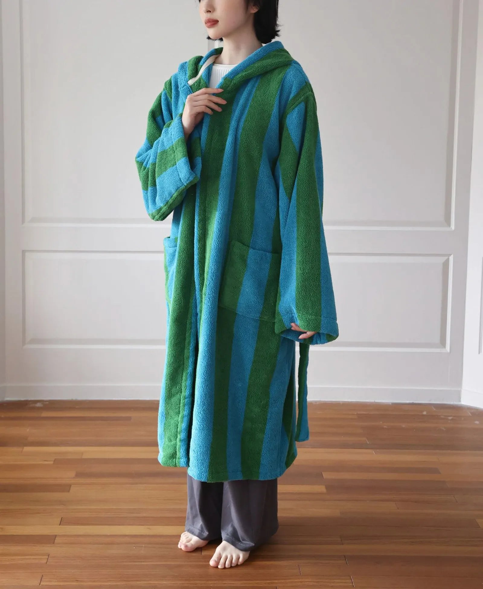 Full body front view of the plush bold striped hooded robe in green and blue - RoomDen