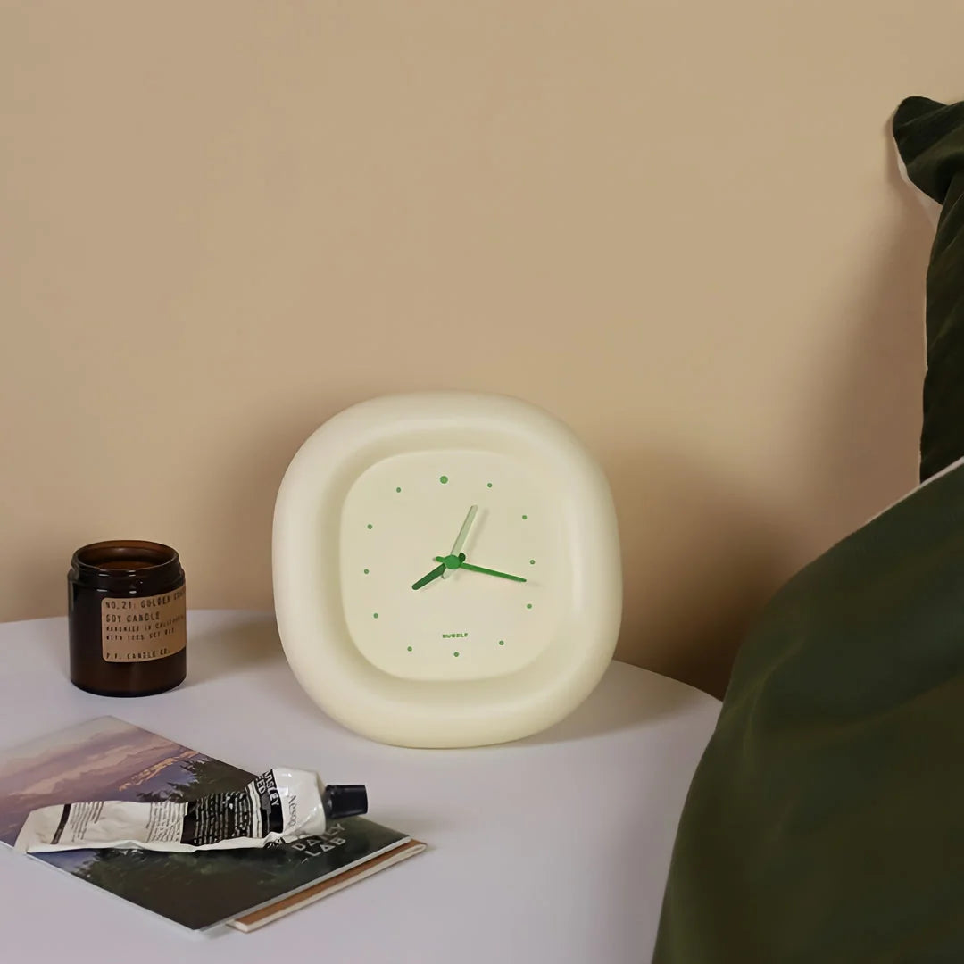 Lifestyle scene of the Creamy Beige Puffy Bubble Table Clock on a white nightstand in a cozy bedroom - RoomDen