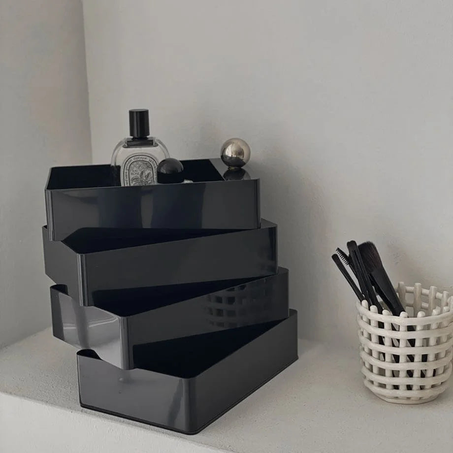 Sleek Minimalist ABS Rotating Makeup Organizer in Black, shown open on a white shelf. - RoomDen
