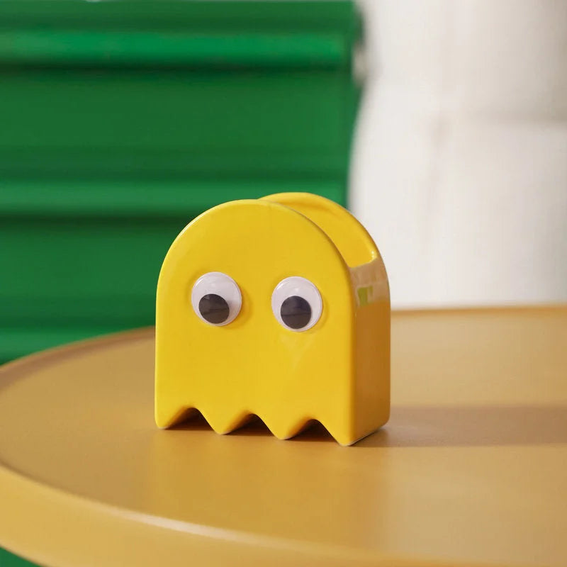 The yellow Retro Ghost Ceramic Pen Holder on a yellow table with a green background - RoomDen.