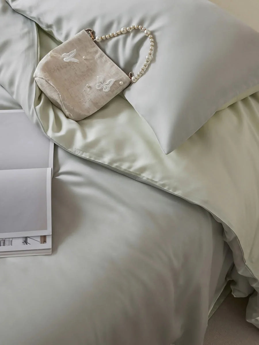 Top-down view of the Sage Mist Tencel bedding, highlighting its soft green hue and silky sheen. - RoomDen