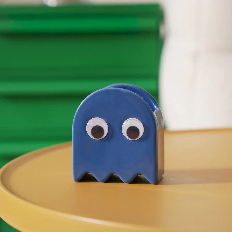 The blue Retro Ghost Ceramic Pen Holder on a yellow table with a green background - RoomDen.