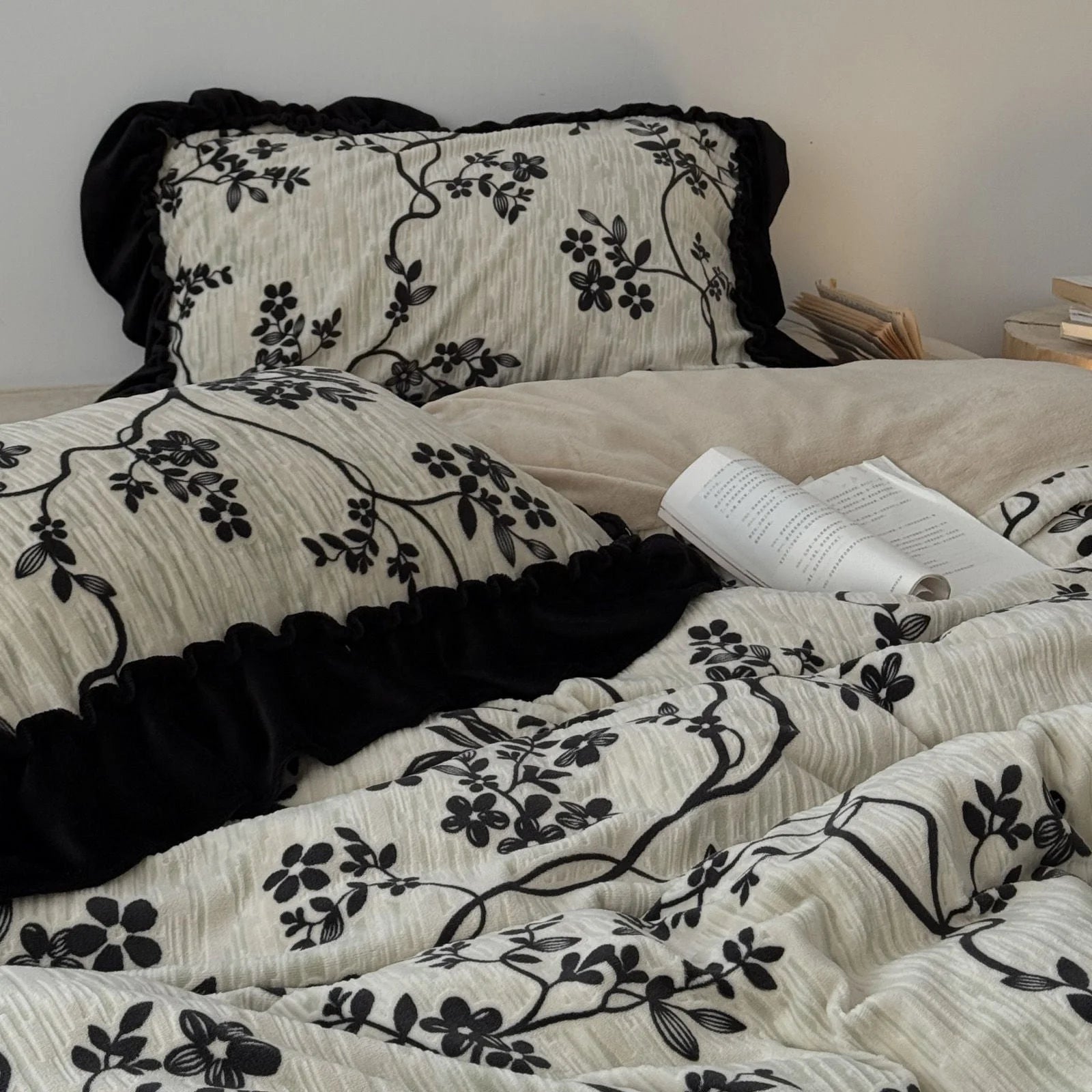 A closer angle of the Ruffled Floral Vine bedding, showing the texture of the fabric and the black ruffle pillow shams - RoomDen.
