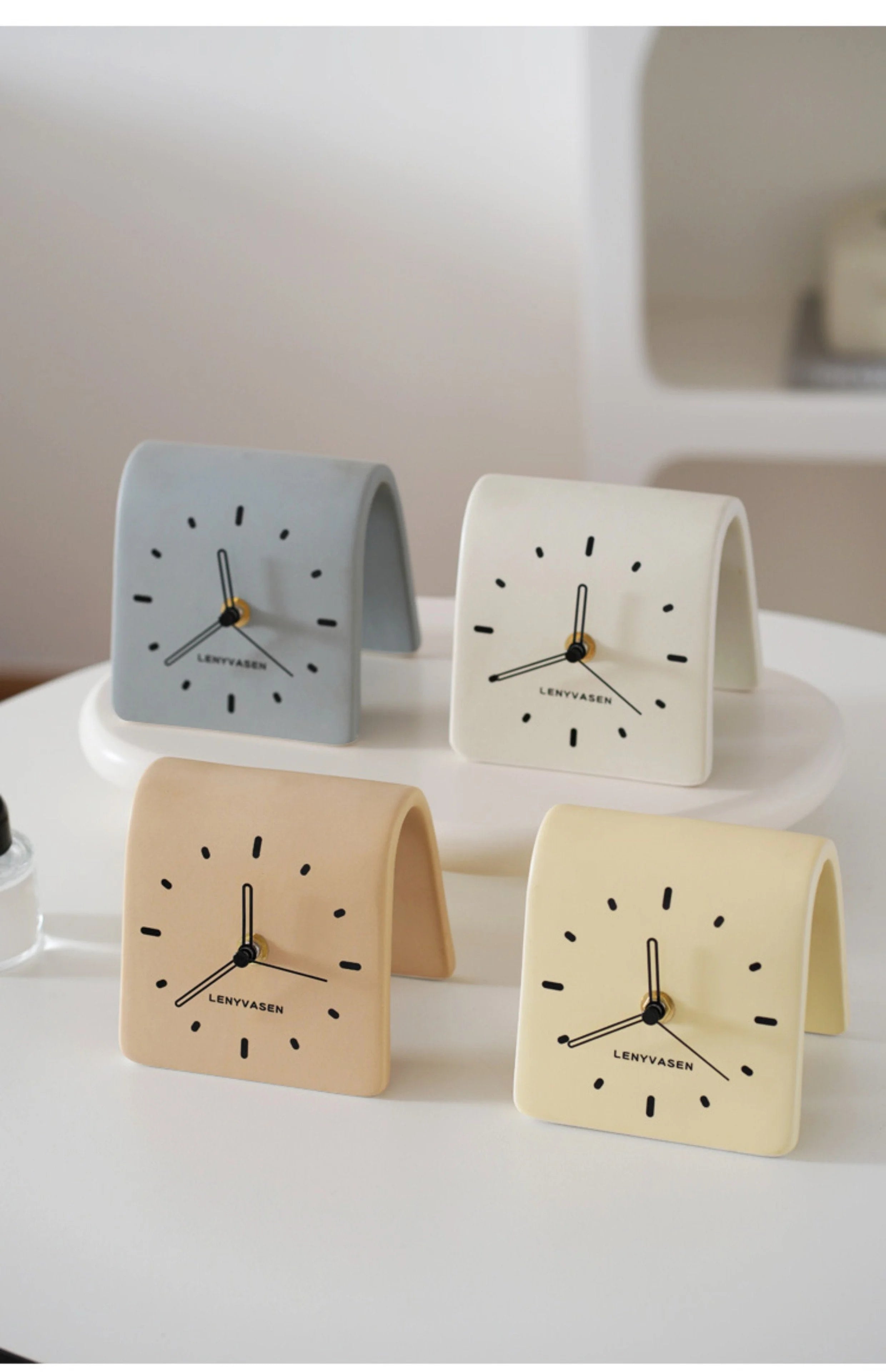 Four variants of the Matte Arch Ceramic Table Clock in Slate Grey, Creamy White, Khaki Beige, and Butter Yellow - RoomDen