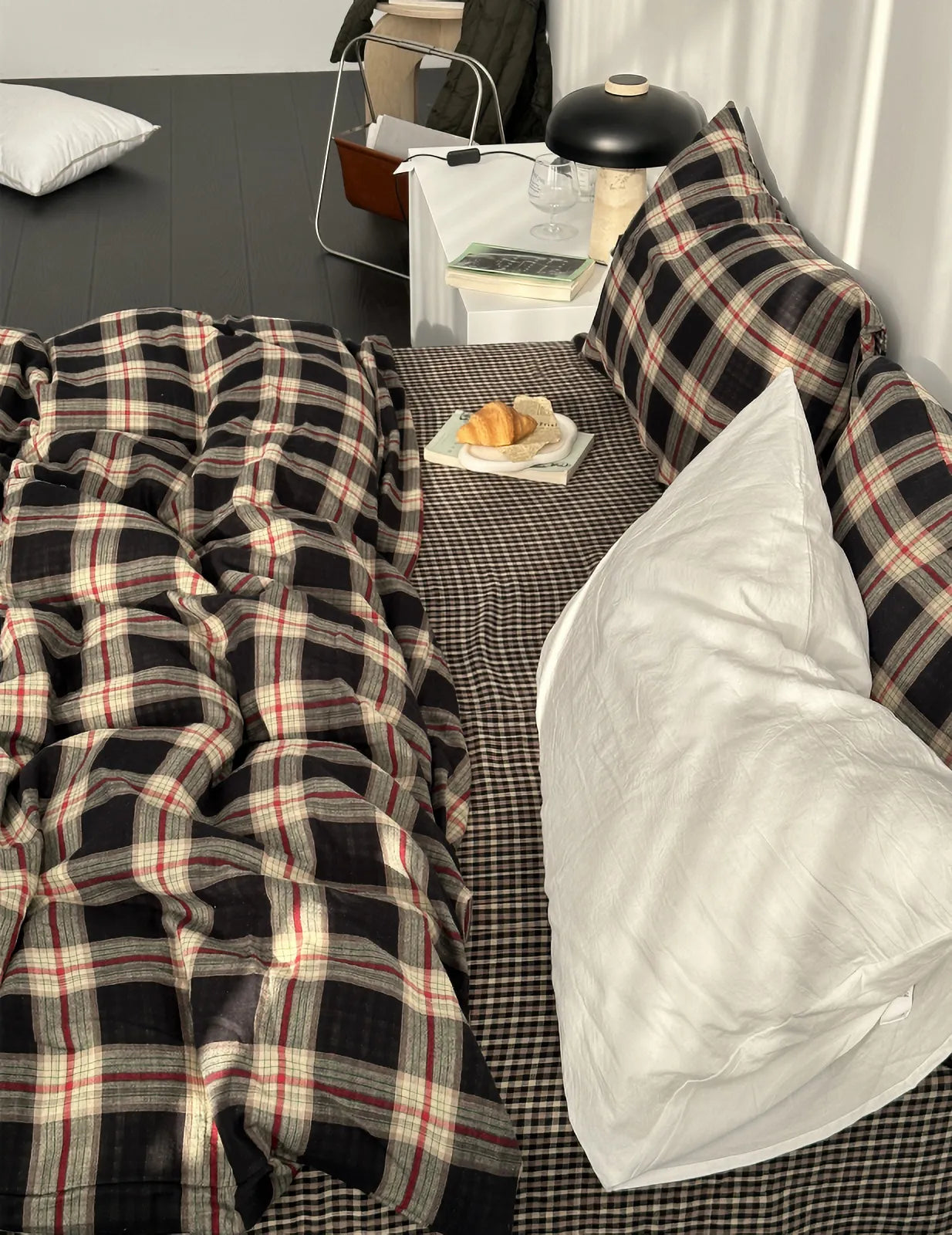 Angled view of the Tartan Plaid & Gingham Bedding Set, showing the layered patterns and a white accent pillow in a cozy bedroom.