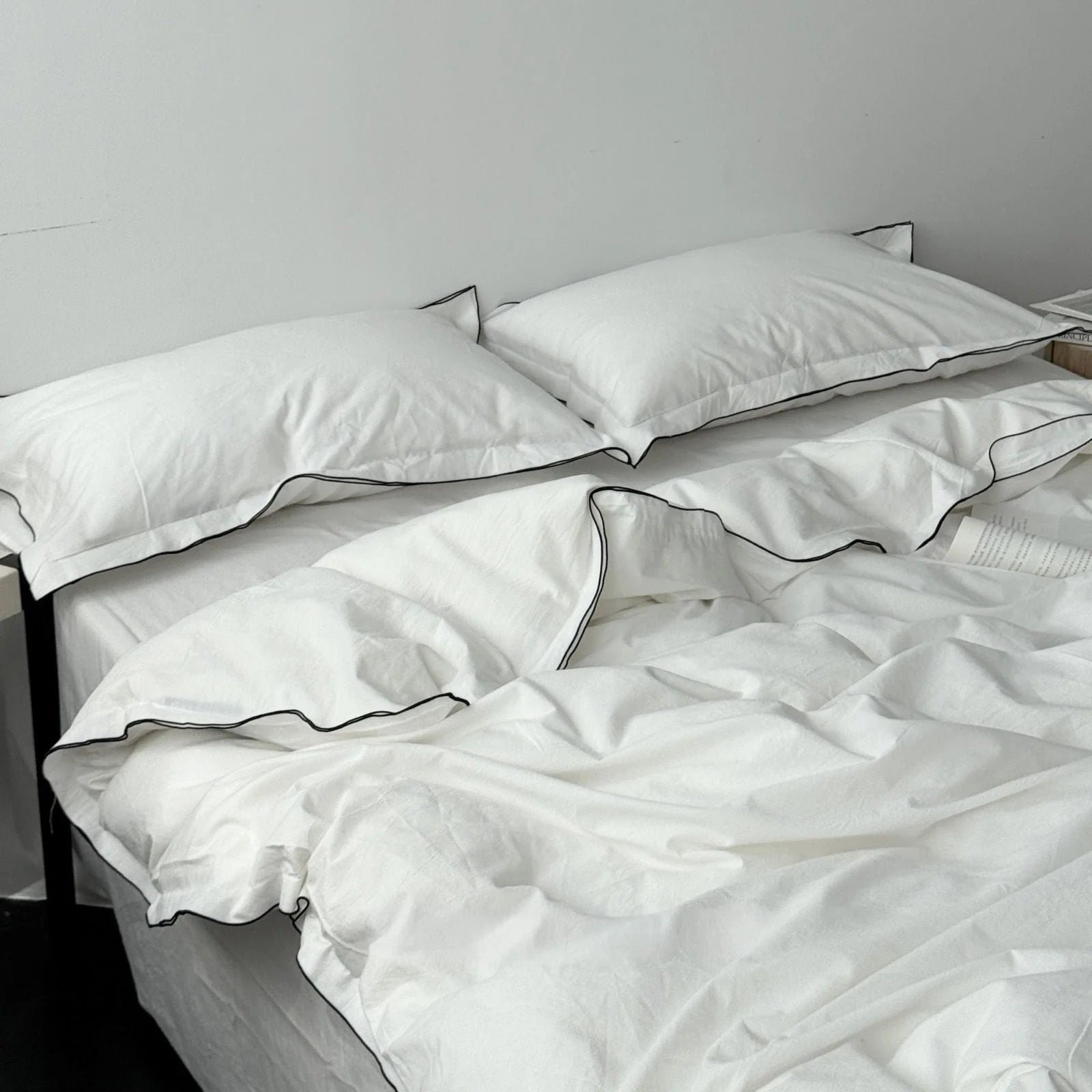 Top-down view of a white and black trim ruffle bedding set, showing the soft texture of the washed cotton fabric. - RoomDen