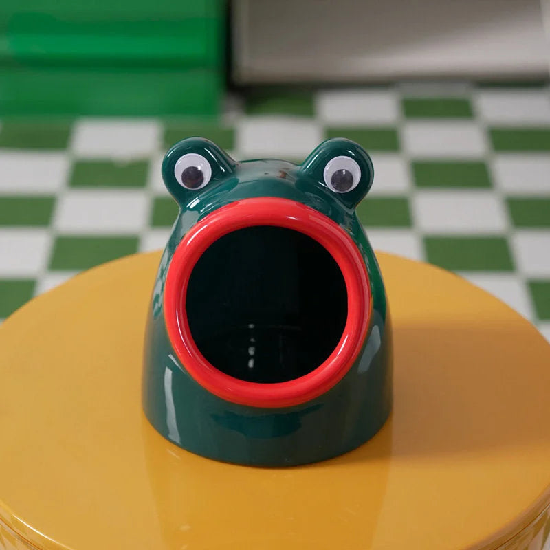 Close-up of the green and red ceramic frog catchall tray on a yellow table. - RoomDen