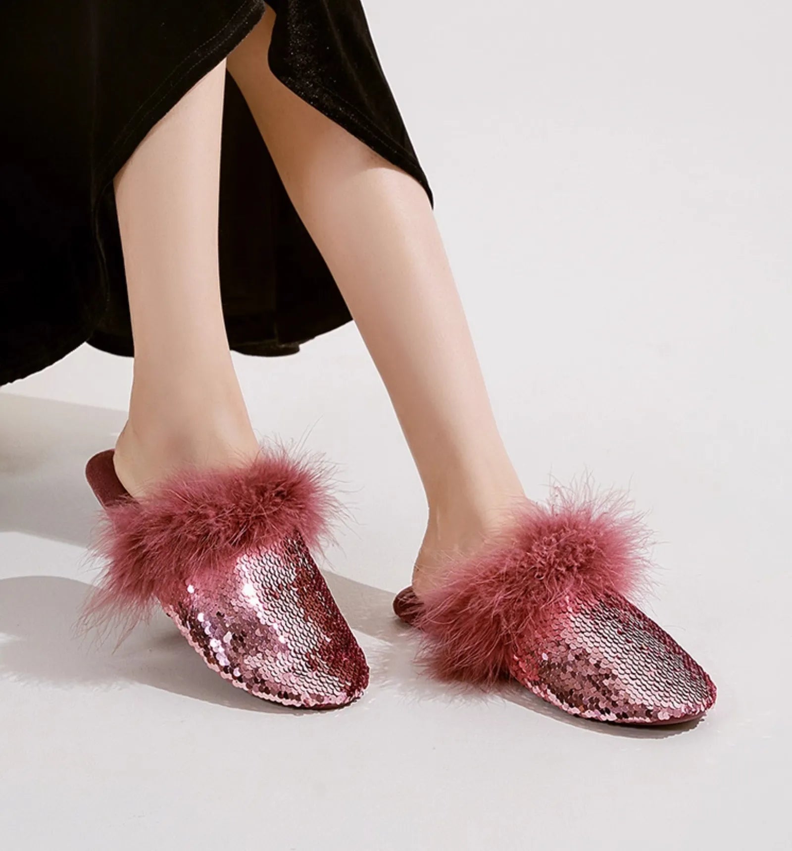 Pink sequin house slippers with matching fluffy trim on model legs - RoomDen