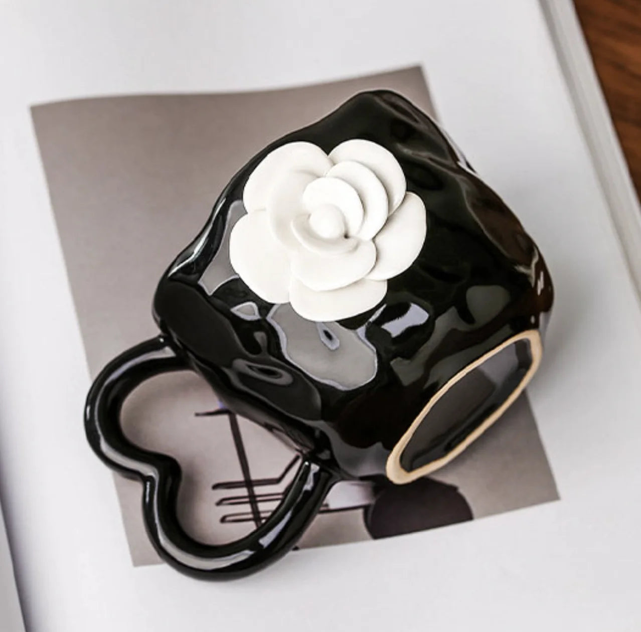 Close-up of the white camellia applique on the black ceramic mug - RoomDen