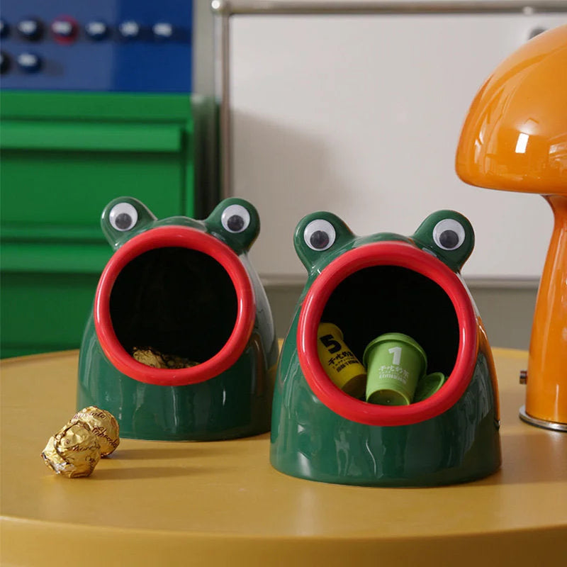 Two green ceramic frog catchall trays on a yellow table with an orange mushroom lamp in the background. - RoomDen