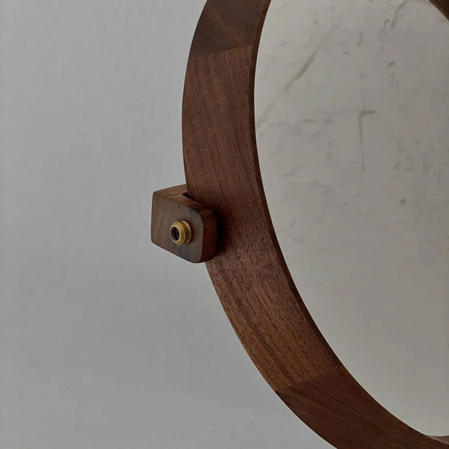 Close-up of the brass hardware and smooth joinery on the walnut frame of the desktop mirror.