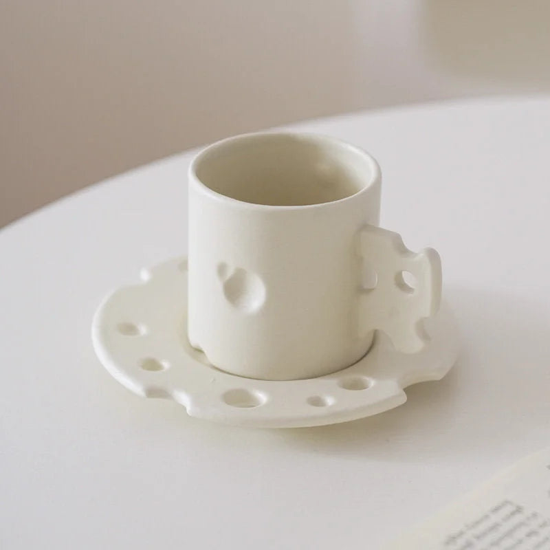 The Cheese Ceramic Mug & Saucer Set in Cream White on a clean white surface. - RoomDen