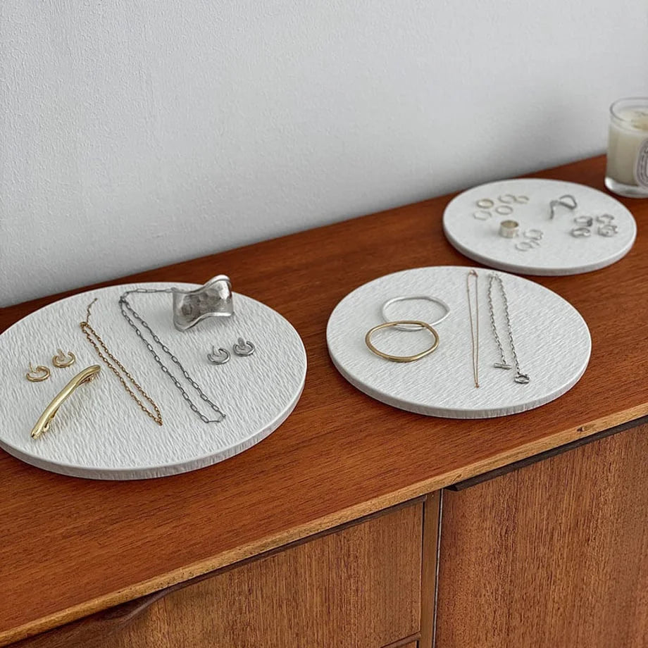 Three white textured ceramic jewelry trays in different sizes on a wooden dresser, displaying gold and silver jewelry. - RoomDen